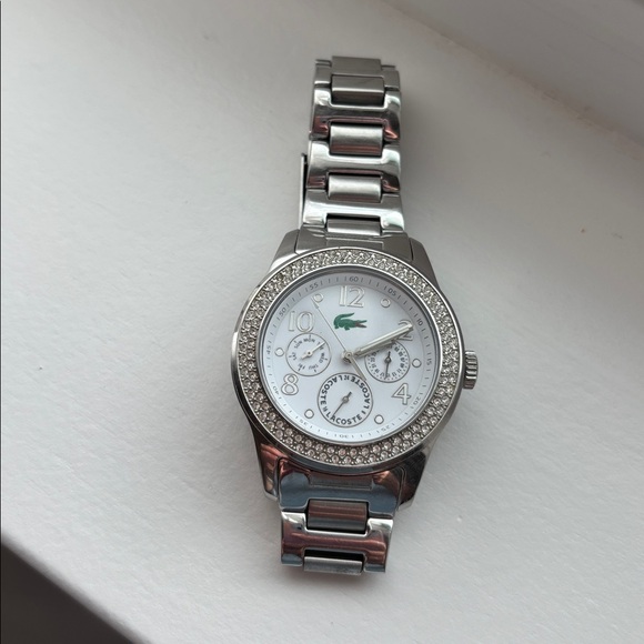 Lacoste stainless steel watch with pavé crystals surrounding watch face. - Picture 2 of 6